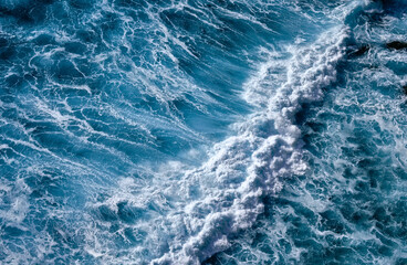 Fototapeta premium Aerial view to seething waves with foam. Waves of the sea meet each other during high tide and low tide
