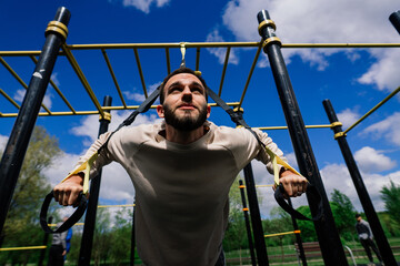 Caucasian sportsman on crossbar during street workout. Healthy lifestyle and street sport concept