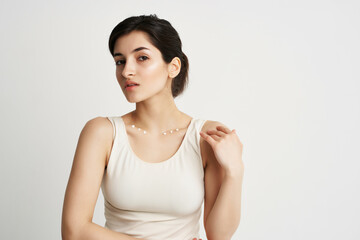 Obraz premium cute brunette in white tank top with lotion apply cream to skin