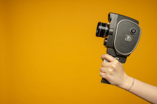 woman Hand holding small video old retro black camera 8 mm isolated on white background
