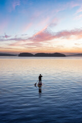 Adventurous Caucasian Adult Woman on a Stand Up Paddle Board is paddling on the West Coast of...