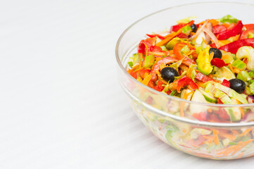 Glass salad bowl on a white stripy tablecloth