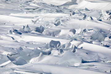 Gremyachinsk, Baikal, Russia February 10, 2019. Texture (background) ice on winter snow-covered Baikal. Ice hummocks. The purest water and ice of Baikal.