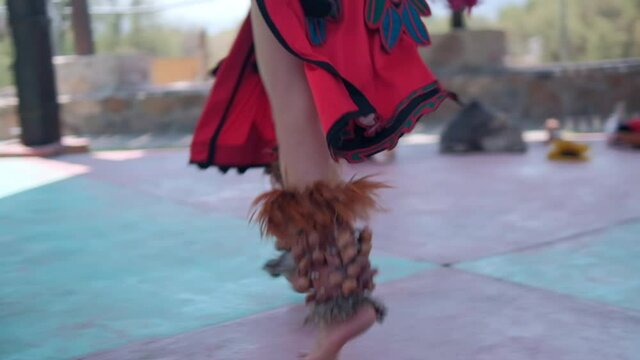 Dancer performing dance of pre-Hispanic culture with bright sky as background