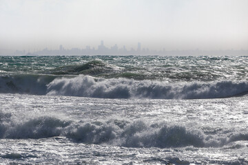 Byblos (Jbeil), Lebanon January 15, 2019 stormy Mediterranean sea, waves, Beirut city skyline in the background.