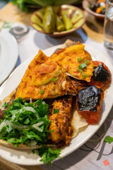 Beirut, Lebanon, January 18, 2019, Mediterranean Lebanese cuisine. Traditional grilled food. Fried tomatoes. Chicken kebab, flatbread, greens garnish.
