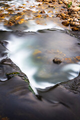 Photograph of the San Isidro river as it passes through the town of Collanzo in the council of Aller.The photo is shot during the day with long exposure to achieve the silk effect in the water.
