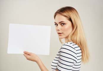 Obraz na płótnie Canvas blonde in a striped t-shirt white sheet of paper
