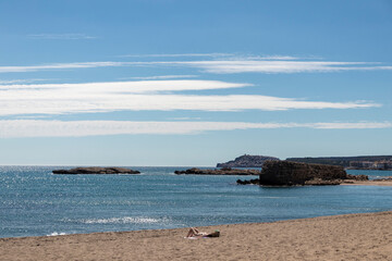 woman sunbathing topless on a lonely beach on the costa brava