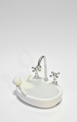 clay man bath in toy bathtub and water tap for used in bathroom full with soap bubble on white...