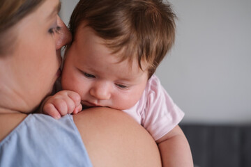 Attractive happy mothers face kiss little baby girl. Happy family