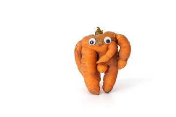 Funny carrot with eyes isolated on white background. Ugly vegetables. Food waste concept. Copy...