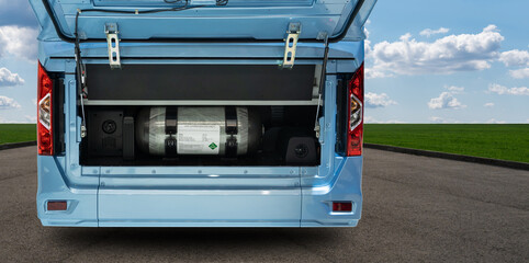A hydrogen fuel cell bus with an open hood and a hydrogen tank inside.