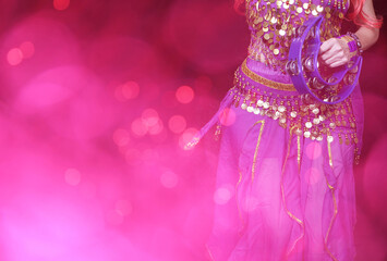 Belly Dancer wearing purple dance costume close up with bokeh