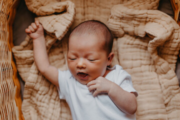 portrait of a cute newborn baby who just woke up, bubbling and stretching
