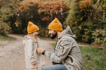 young, stylish bearded father walking with his little daughter in nature at sunset. Family photos of father and one child.