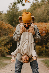 Happy father and daughter playing while walking in a beautiful autumn park. Ideal weekend father with his little daughter. selective focus, noise effect..