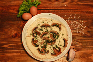 Top view of cheese and mushroom omelette decorated with eggs on wooden board