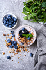 Fototapeta na wymiar Yogurt dessert with berries, granola and mint in glass