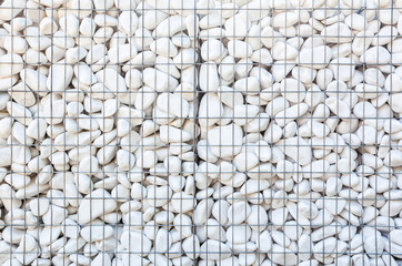Many white stones in a cage. Metal fence from rockfall.