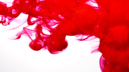 Blood-red cloud of ink on a white background. Awesome abstract background. Drops of red ink in water. Red watercolor ink in water on a white background.