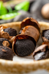 Fermented black garlic. The color is a result of the Maillard reaction or caramelization. Black garlic can help to regulate blood sugar levels. negative space. selective focus.