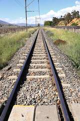 Fototapeta na wymiar A photo of railway lines in a rural setting in bright sunshine. It runs through the farming community of De Doorns in the Western Cape Province in South Africa.