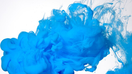 Blue paints are mixed in water. Colored cloud of ink on a white background. Blue watercolor ink in water on a white background.