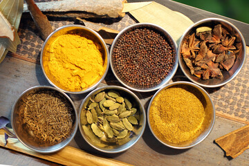 especias y condimentos exóticos de oriente en recipiente plateado, cúrcuma, pimienta, canela,...