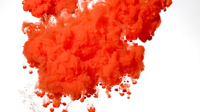 Beautiful abstract background. Red-orange acrylic paints are mixed in water. Colored cloud of ink on a white background.