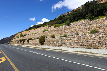 A gabion retaining wall next to a roadway  that runs through the farming community of De Doorns in...