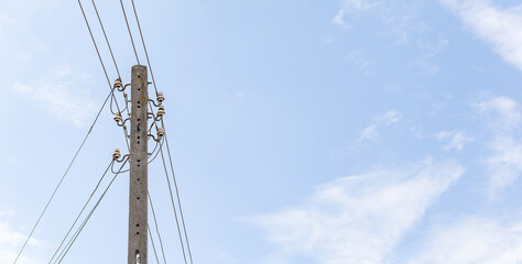 Old fashioned retro medium voltage power lines single pole with cables, wires. Blue sky simple high resolution wide background, banner, copy space. Power generation and transmission industry concept