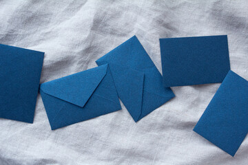 5枚の青い封筒とグレーの麻布の背景 - obrazy, fototapety, plakaty