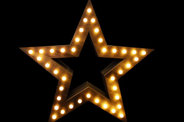 Wooden star with lights on black background