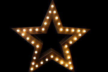 Wooden star with lights on black background