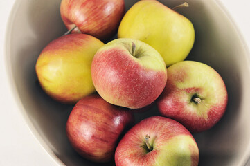 Fototapeta na wymiar ripe red and green apples in a deep dish