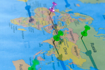 Fototapeta na wymiar Location Pin on a World Map. Global Mapping. Close up. Table Top View. Selective focus. Shallow depth of field.