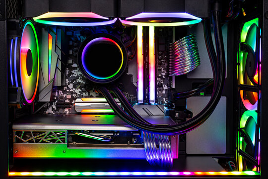 Inside view black high end custom colorful illuminated bright rainbow RGB LED gaming pc. Computer power hardware and technology concept background