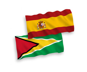 National vector fabric wave flags of Co-operative Republic of Guyana and Spain isolated on white background. 1 to 2 proportion.