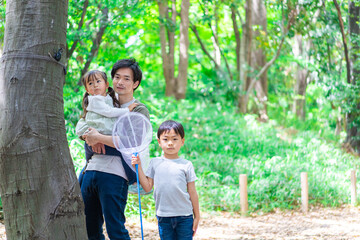 虫採りをするお父さんと子どもたち