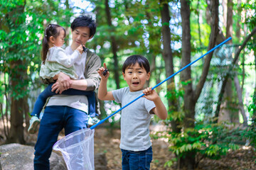 虫採りをするお父さんと子どもたち
