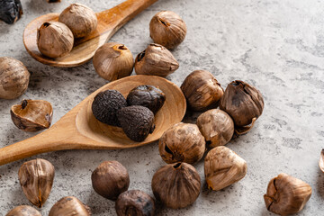 Fermented black garlic. The color is a result of the Maillard reaction or caramelization. Black garlic can help to regulate blood sugar levels. negative space. selective focus.