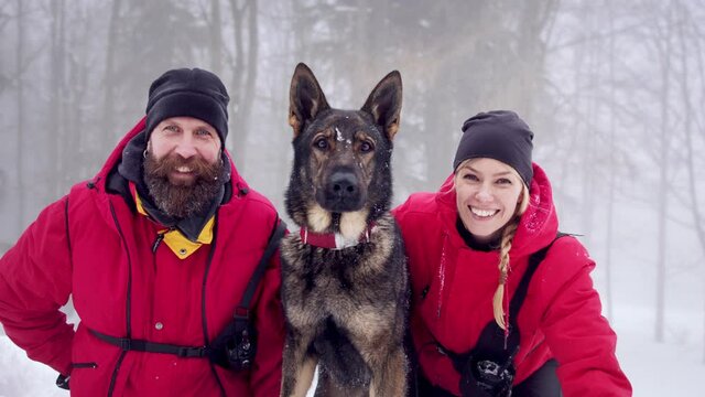 Mountain rescue service with dog on operation outdoors in winter in forest.