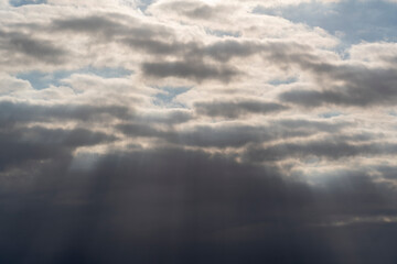 ray tuft (light tuft), sun rays fight through a gray cloud layer, cloud rays, twilight rays, concept of hope, religion and divinity