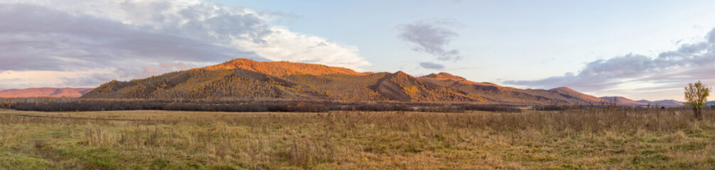 Evening panorama of the mountains.  Autumn mountains illuminated by the sun at sunset.