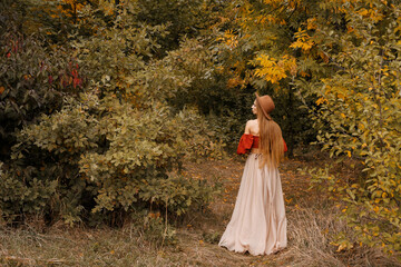 Obraz na płótnie Canvas model in autumn clothes on an autumn background in the forest. free space for text