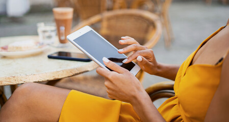 Uses a laptop to surf the internet. Writes to the client by email. A female freelancer is sitting in a summer cafe.