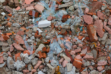 Building materials after the destruction of the house, construction debris - old broken red and white bricks, broken glass