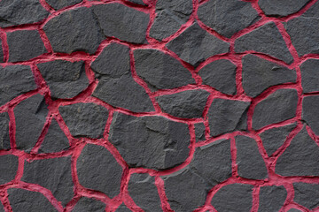 Beautiful building background - the foundation of the house of large stones and decorated with black and red paint