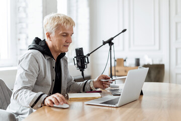 Speaks into the microphone in the studio. Live podcast recording for the show. The presenter on the...